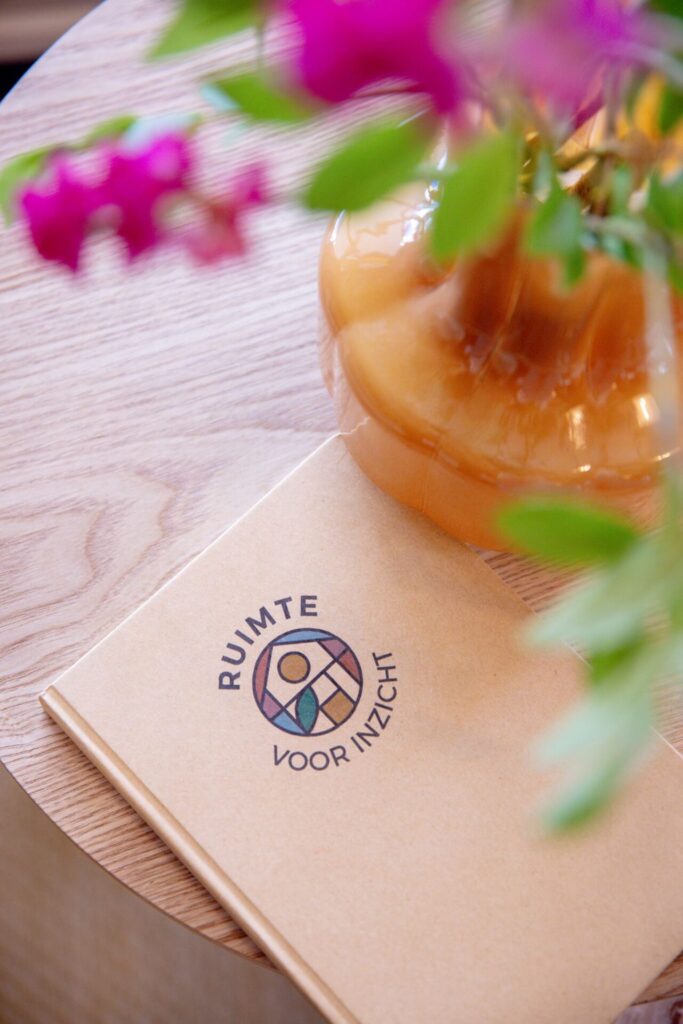 Notitieboek bij een vaas met bloemen in vergaderlocatie Ruimte voor Inzicht in Oisterwijk